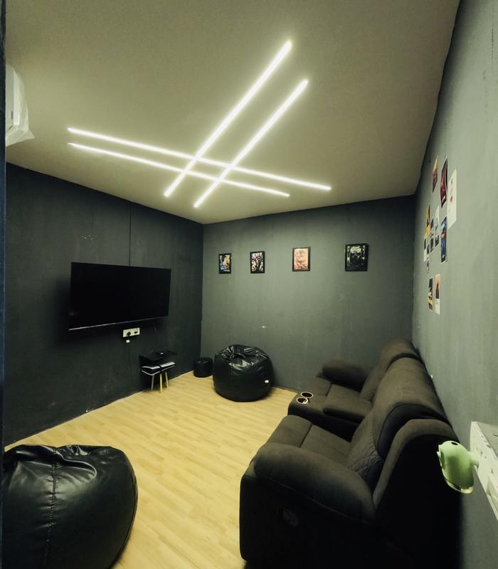 Private gaming room with LED ceiling lights, TV and recliner